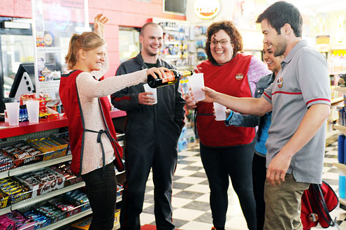characters toasting each other with plastic cups in a convenience store